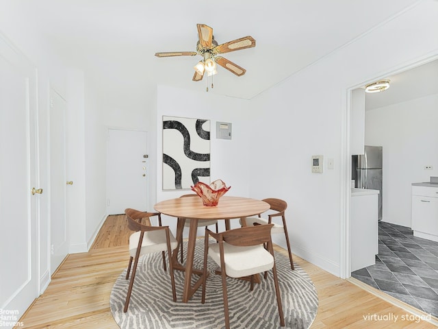 dining space featuring ceiling fan, wood finished floors, and baseboards