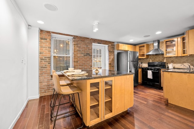 kitchen with tasteful backsplash, wall chimney range hood, black range with electric stovetop, sink, and stainless steel refrigerator