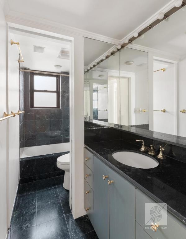 full bathroom featuring tiled shower / bath combo, vanity, ornamental molding, and toilet