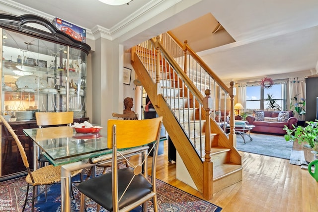 dining space with ornamental molding and hardwood / wood-style floors