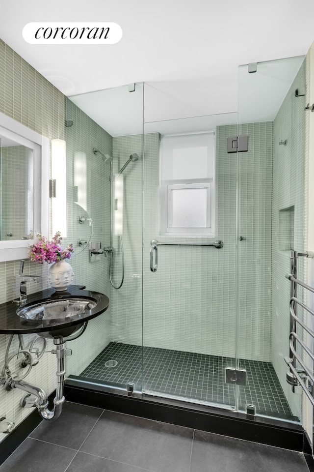 full bath featuring a sink, a shower stall, and tile patterned floors