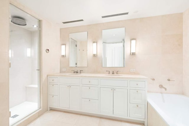 bathroom featuring vanity, tile patterned floors, shower with separate bathtub, and tile walls