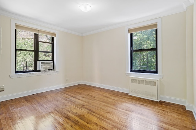 empty room featuring radiator, crown molding, and light hardwood / wood-style flooring