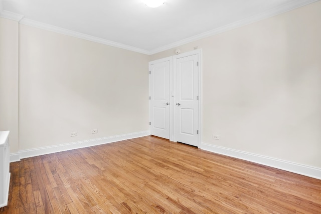 empty room featuring crown molding and light hardwood / wood-style flooring