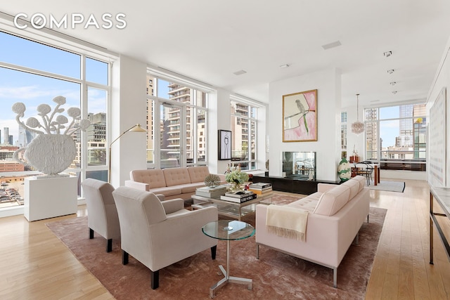 living room featuring a wall of windows and hardwood / wood-style flooring