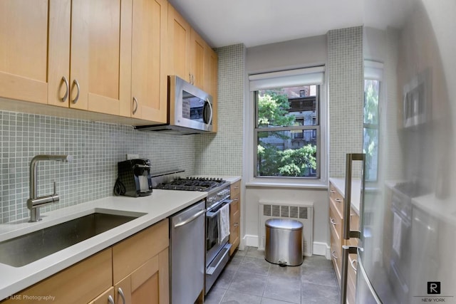 kitchen featuring light tile patterned floors, stainless steel appliances, decorative backsplash, light brown cabinetry, and sink