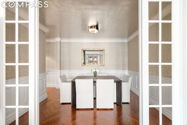 unfurnished dining area featuring dark parquet flooring and crown molding