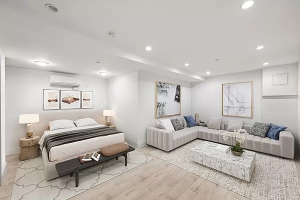 bedroom featuring a wall unit AC and light hardwood / wood-style floors