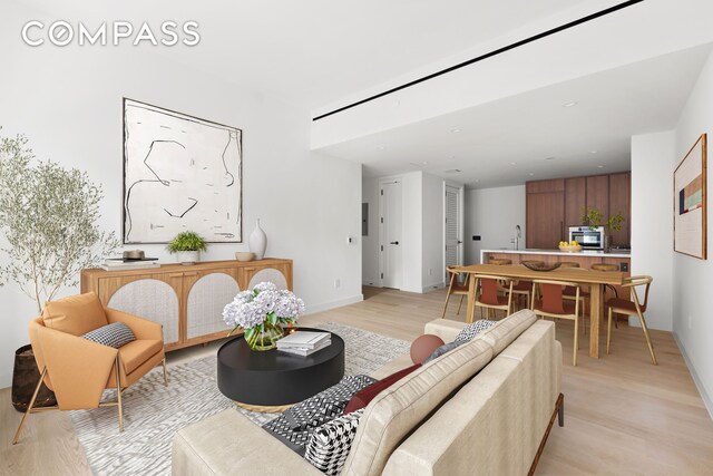 living room with sink and light hardwood / wood-style floors