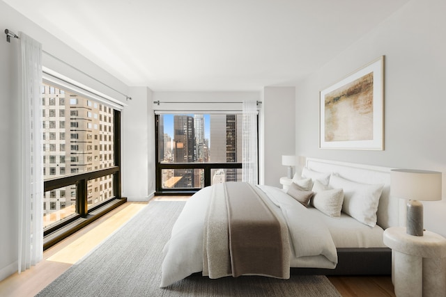 bedroom featuring wood finished floors and a city view
