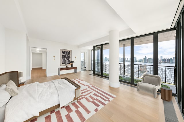 100 Vandam St Unit 20-A, New York City, NY 10013 - bedroom with access to outside, light wood-type flooring, a water view, expansive windows, and baseboards
