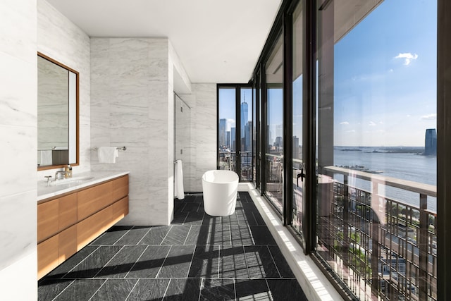 100 Vandam St Unit 20-A, New York City, NY 10013 - bathroom featuring vanity, a water view, a soaking tub, tile walls, and a view of skyline
