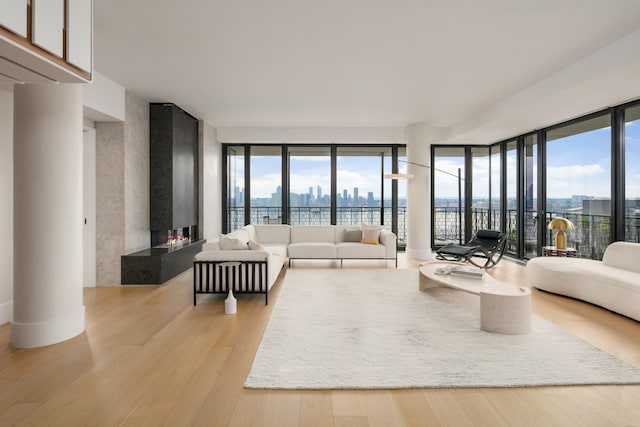 100 Vandam St Unit 20-A, New York City, NY 10013 - living area with a multi sided fireplace, light wood-style floors, healthy amount of natural light, and a view of city