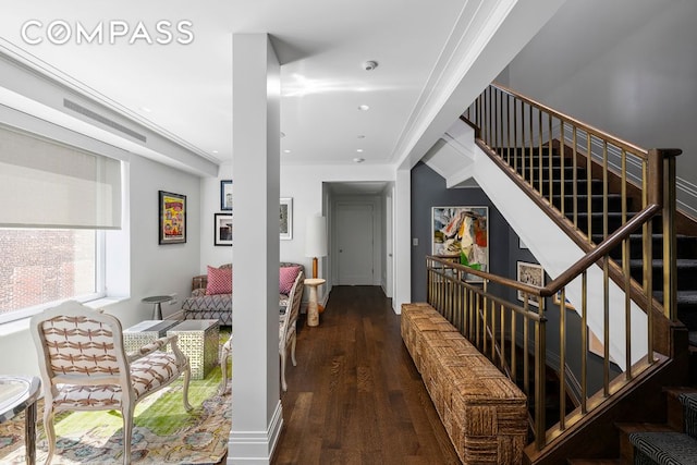 hall featuring dark wood-style floors, ornamental molding, and stairs