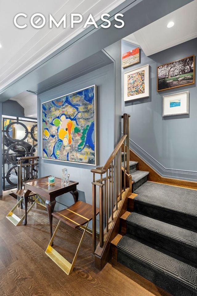 stairway with baseboards, wood finished floors, and recessed lighting