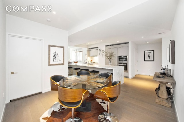 dining room featuring sink and light hardwood / wood-style floors