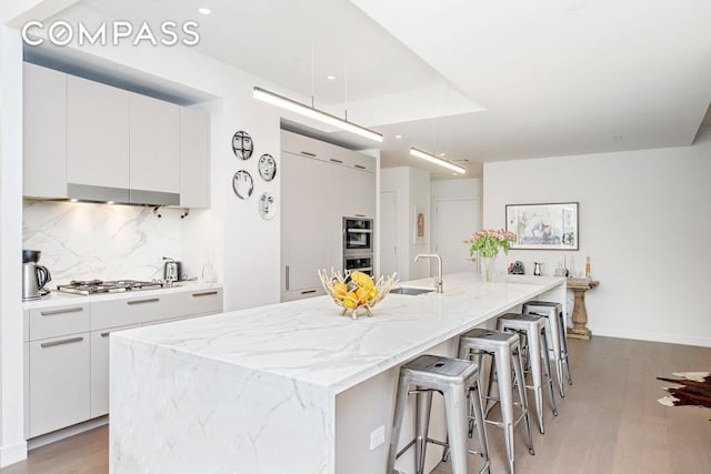 kitchen featuring white cabinetry and a kitchen island with sink