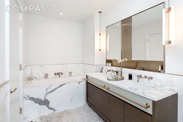 bathroom featuring a washtub and vanity