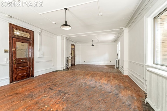 unfurnished room featuring radiator heating unit and crown molding