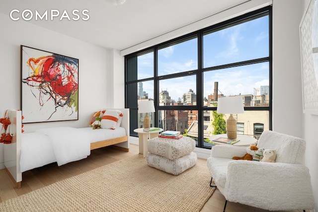 interior space featuring a view of city, multiple windows, and wood finished floors