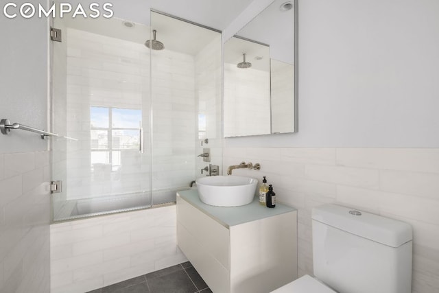 bathroom with toilet, a shower with door, vanity, and tile patterned flooring