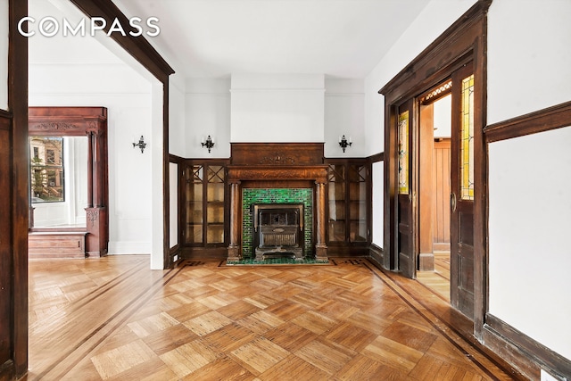 unfurnished living room with a wood stove and baseboards