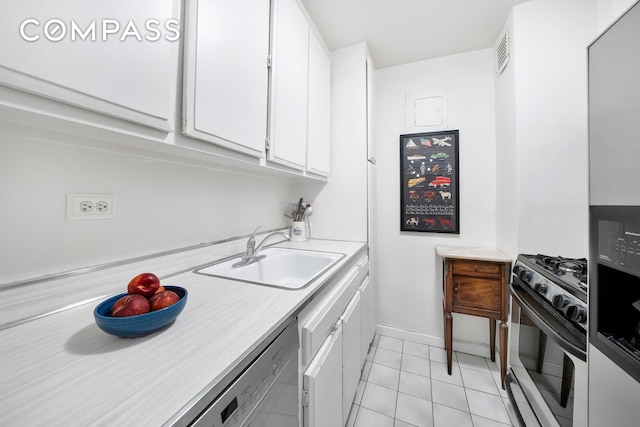 kitchen with light tile patterned floors, white cabinets, stainless steel appliances, light countertops, and a sink