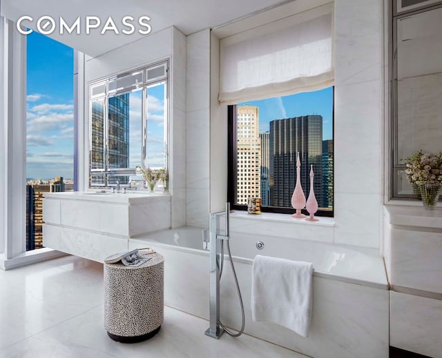 bathroom with tile patterned floors, a wealth of natural light, a garden tub, and a city view