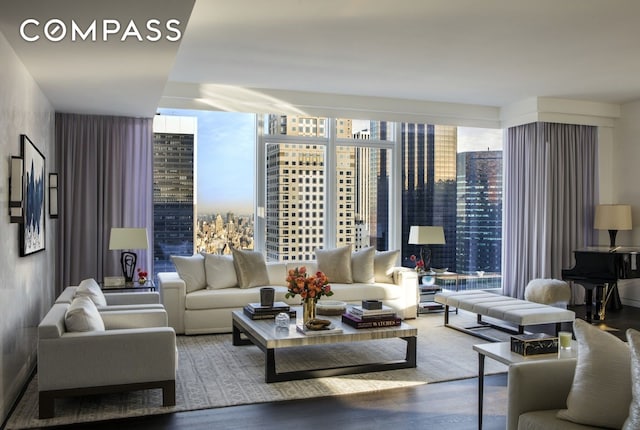 living area with expansive windows, wood finished floors, and a city view