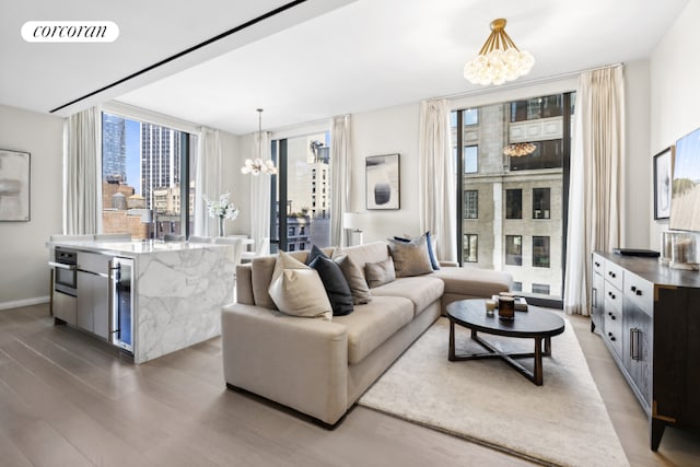 living room with a chandelier, beverage cooler, dark hardwood / wood-style flooring, and expansive windows