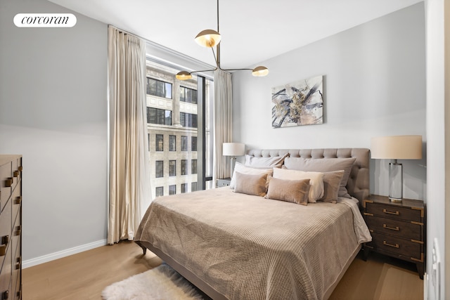 bedroom featuring baseboards and wood finished floors