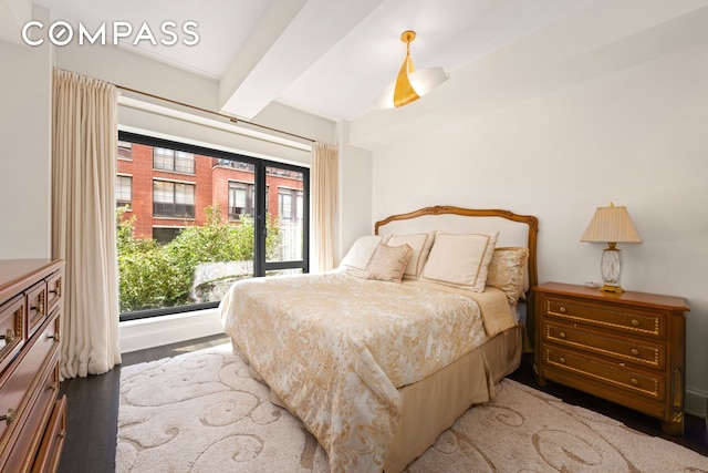 bedroom featuring beam ceiling and wood finished floors