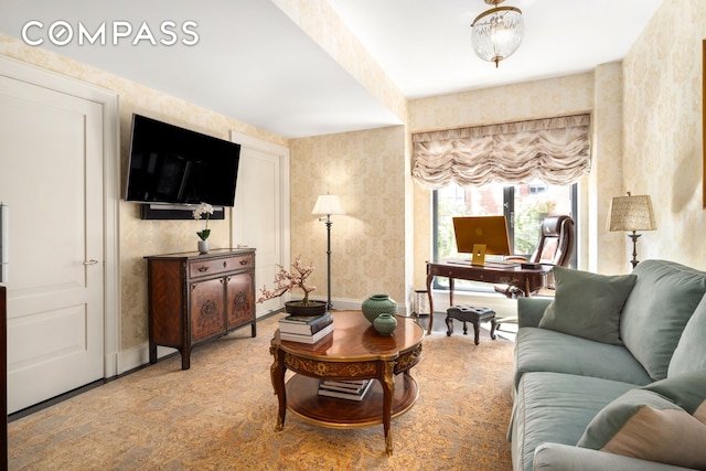 living room featuring baseboards and wallpapered walls