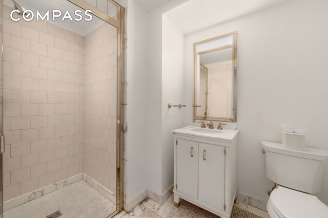 bathroom featuring vanity, a shower stall, toilet, and baseboards