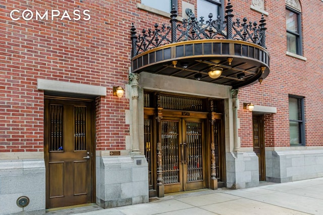 property entrance featuring french doors and brick siding