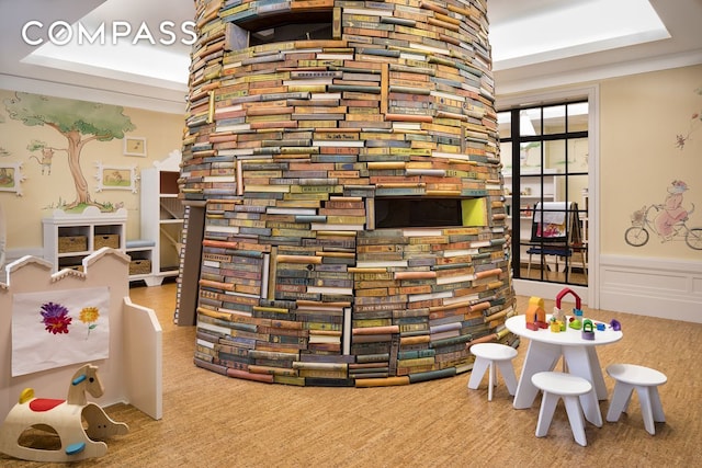 game room featuring ornamental molding, a wainscoted wall, and a decorative wall