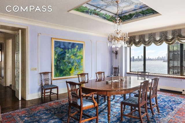 dining room featuring a tray ceiling, crown molding, a water view, an inviting chandelier, and dark wood-type flooring