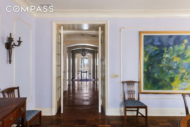 hallway with ornamental molding, arched walkways, parquet floors, and baseboards