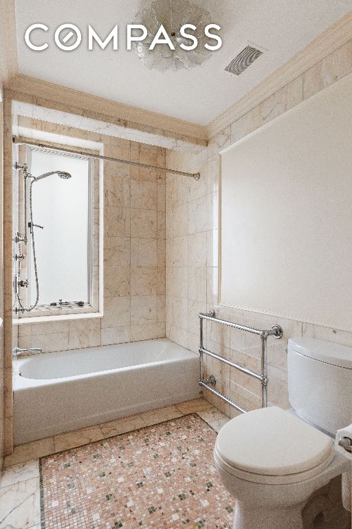 full bath featuring visible vents, ornamental molding, bathing tub / shower combination, and toilet