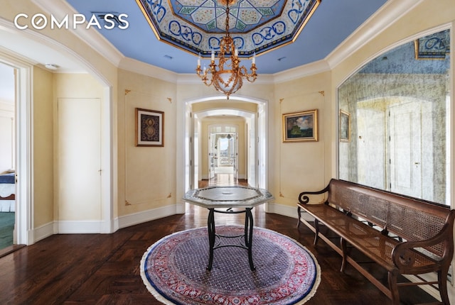 entryway featuring arched walkways, crown molding, baseboards, and an inviting chandelier