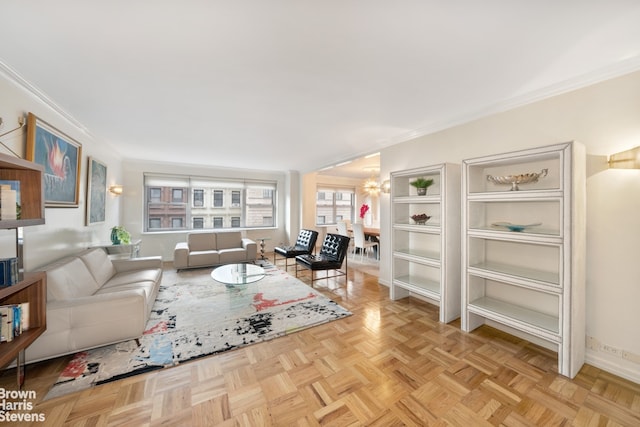 living area with crown molding, baseboards, and a chandelier