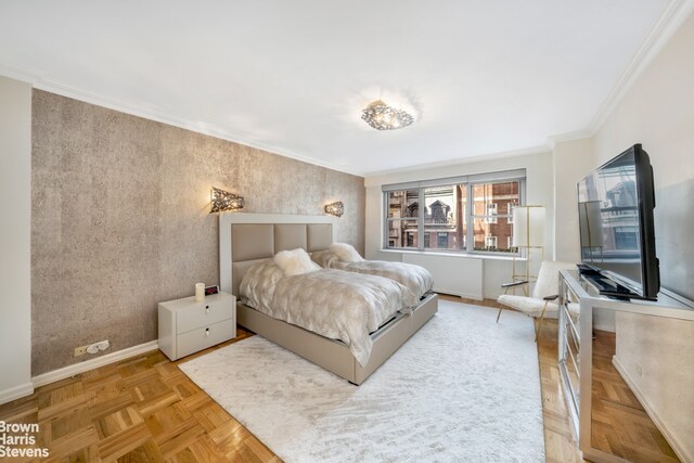 living room featuring light parquet flooring, ornamental molding, and an inviting chandelier