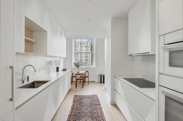 kitchen with a sink, decorative backsplash, modern cabinets, and white oven