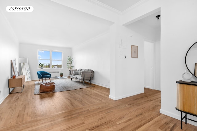living room with wood finished floors, ornamental molding, radiator heating unit, and baseboards