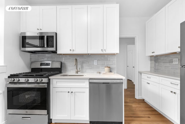 kitchen featuring appliances with stainless steel finishes, a sink, and white cabinets
