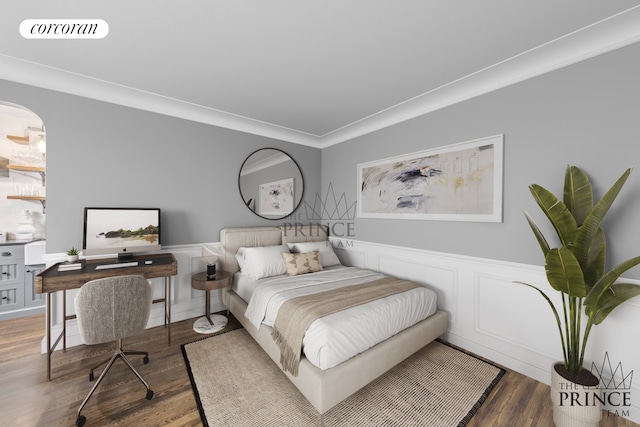 bedroom featuring visible vents, wood finished floors, wainscoting, a decorative wall, and crown molding