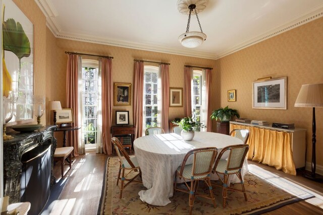 dining room with dark hardwood / wood-style flooring and crown molding