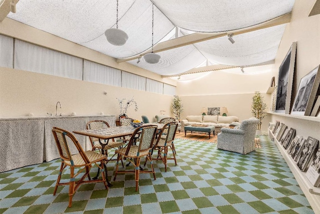 dining area with high vaulted ceiling and a textured ceiling