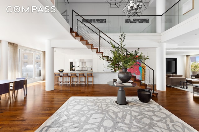 entrance foyer featuring stairs, a high ceiling, wood finished floors, and a notable chandelier