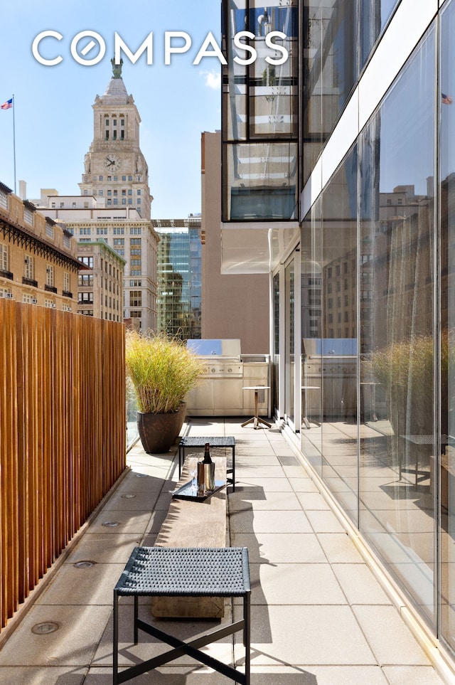 view of patio with exterior kitchen, a city view, and a grill